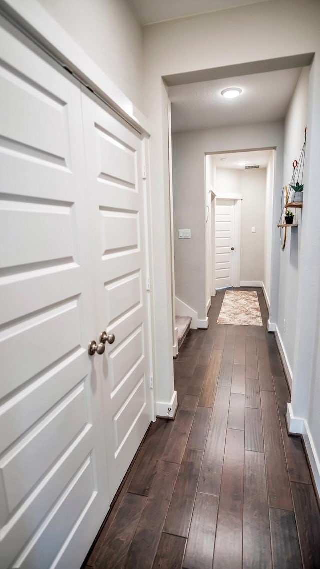 hallway featuring dark wood-style floors, stairs, and baseboards