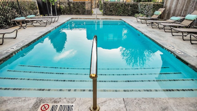 pool featuring a patio area and fence