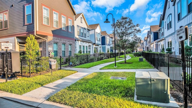 surrounding community with mail area, a yard, fence, and a residential view