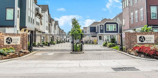 view of gate featuring fence and a residential view