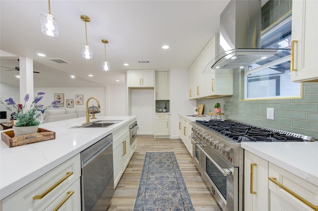 kitchen with a sink, appliances with stainless steel finishes, island exhaust hood, and white cabinets