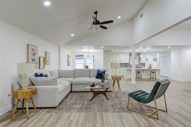 living area featuring high vaulted ceiling, visible vents, light wood-style flooring, and baseboards