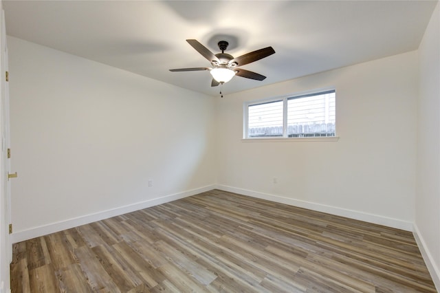 spare room with ceiling fan, baseboards, and wood finished floors