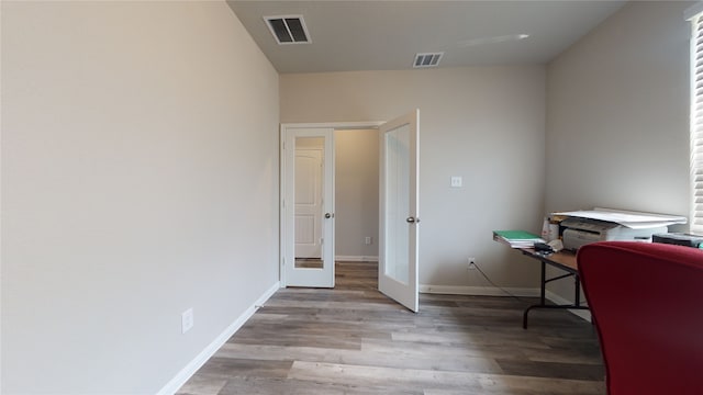 office space with french doors, light wood-style flooring, visible vents, and baseboards