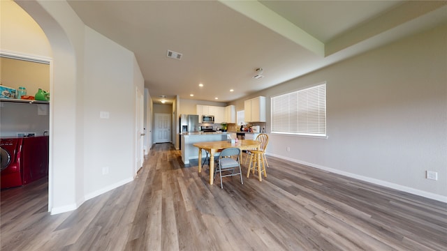 dining space with visible vents, baseboards, and wood finished floors