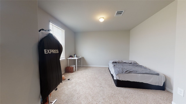 carpeted bedroom with visible vents and baseboards