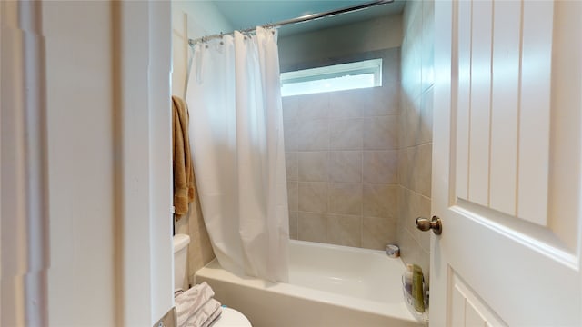 bathroom with shower / tub combo with curtain and toilet