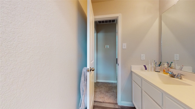 bathroom with visible vents, vanity, and baseboards