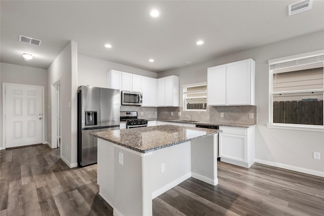 24902 Bastiani Canvas Ln, Katy, TX 77493 - kitchen with appliances with stainless steel finishes, stone counters, a kitchen island, white cabinetry, and tasteful backsplash