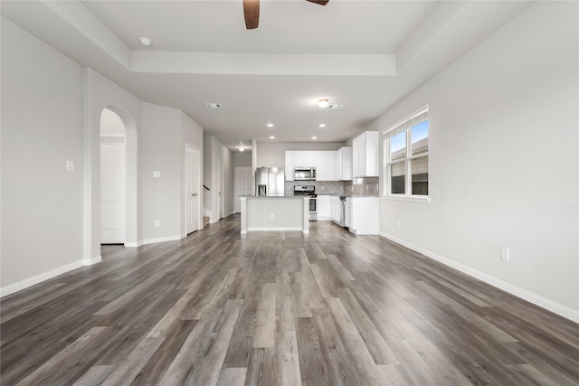 24902 Bastiani Canvas Ln, Katy, TX 77493 - unfurnished living room with ceiling fan, arched walkways, dark wood-type flooring, baseboards, and recessed lighting