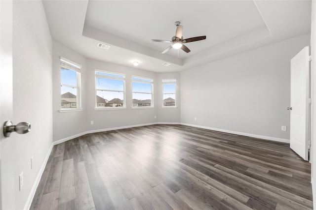 24902 Bastiani Canvas Ln, Katy, TX 77493 - unfurnished bedroom featuring a raised ceiling, multiple windows, dark wood finished floors, and baseboards