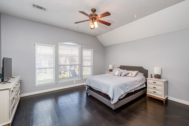 bedroom featuring dark wood-style flooring, lofted ceiling, visible vents, ceiling fan, and baseboards