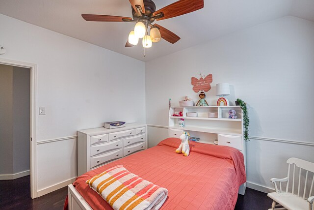 bedroom featuring dark wood-style floors, baseboards, vaulted ceiling, and a ceiling fan