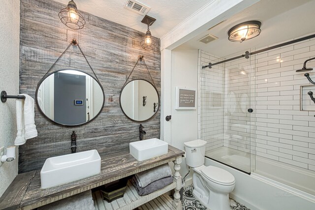 full bathroom featuring toilet, double vanity, a sink, and visible vents