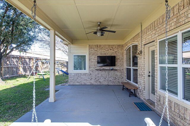 view of patio with ceiling fan, fence, and a playground