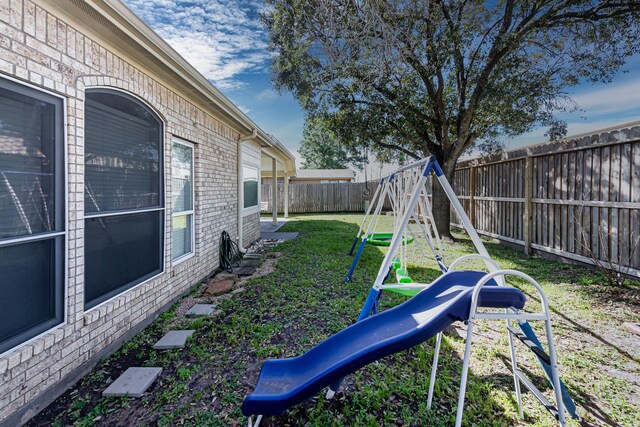 view of yard with a playground and a fenced backyard