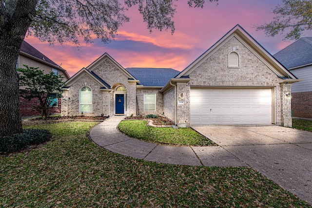 view of front of property with an attached garage, brick siding, concrete driveway, roof with shingles, and a front yard