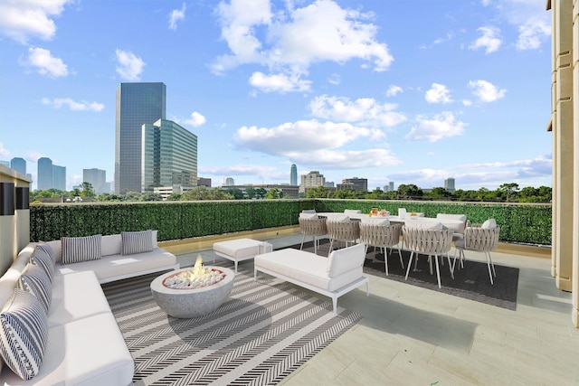 view of patio / terrace with a view of city and an outdoor living space with a fire pit