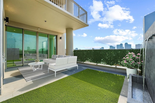 view of yard with outdoor lounge area, a city view, a balcony, and a patio area