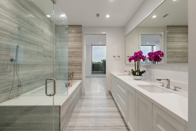 bathroom with double vanity, visible vents, a shower stall, and a sink