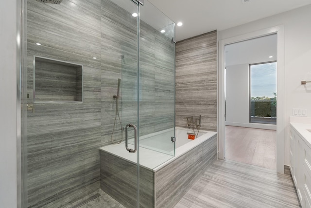 full bath featuring a shower stall, vanity, and a garden tub