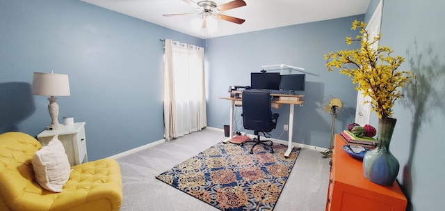 office space featuring a ceiling fan, light carpet, and baseboards