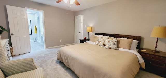 bedroom featuring light carpet, baseboards, a ceiling fan, and ensuite bathroom