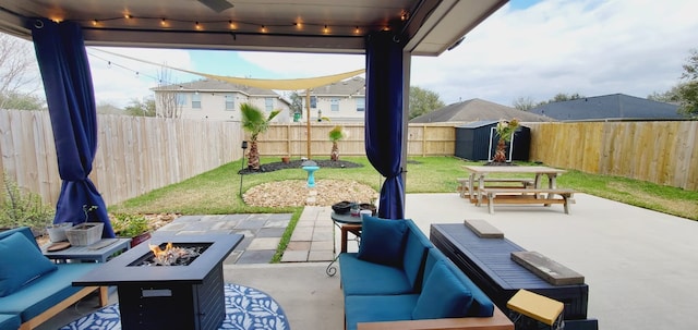 view of patio / terrace featuring outdoor dining space, an outdoor living space with a fire pit, and a fenced backyard