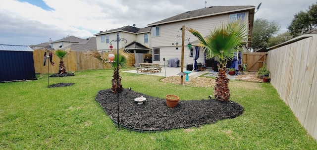 view of yard with an outbuilding, a patio, and a fenced backyard