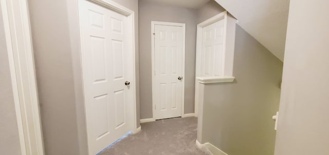 hallway featuring baseboards and carpet flooring