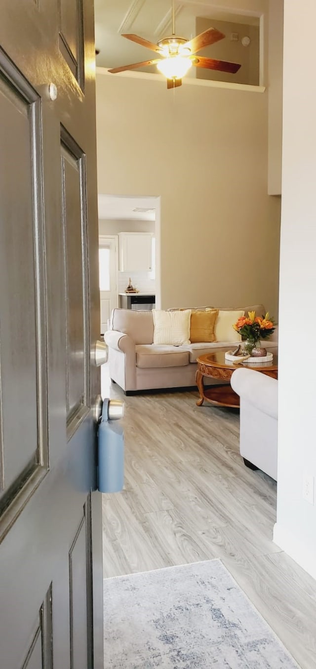 living room with a towering ceiling and wood finished floors