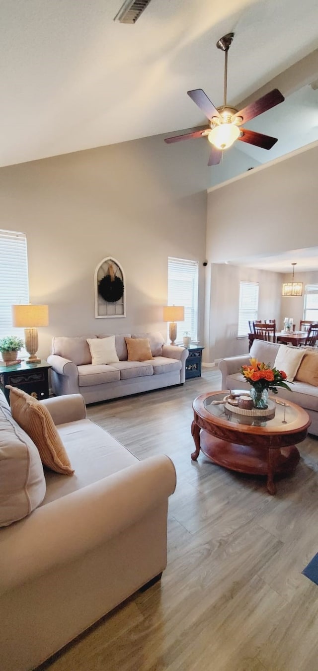 living room featuring high vaulted ceiling, a ceiling fan, and wood finished floors