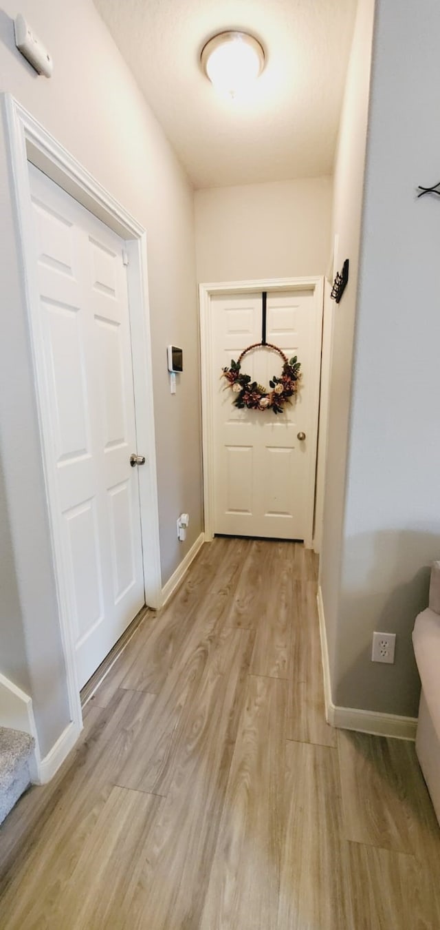 doorway featuring light wood-type flooring and baseboards