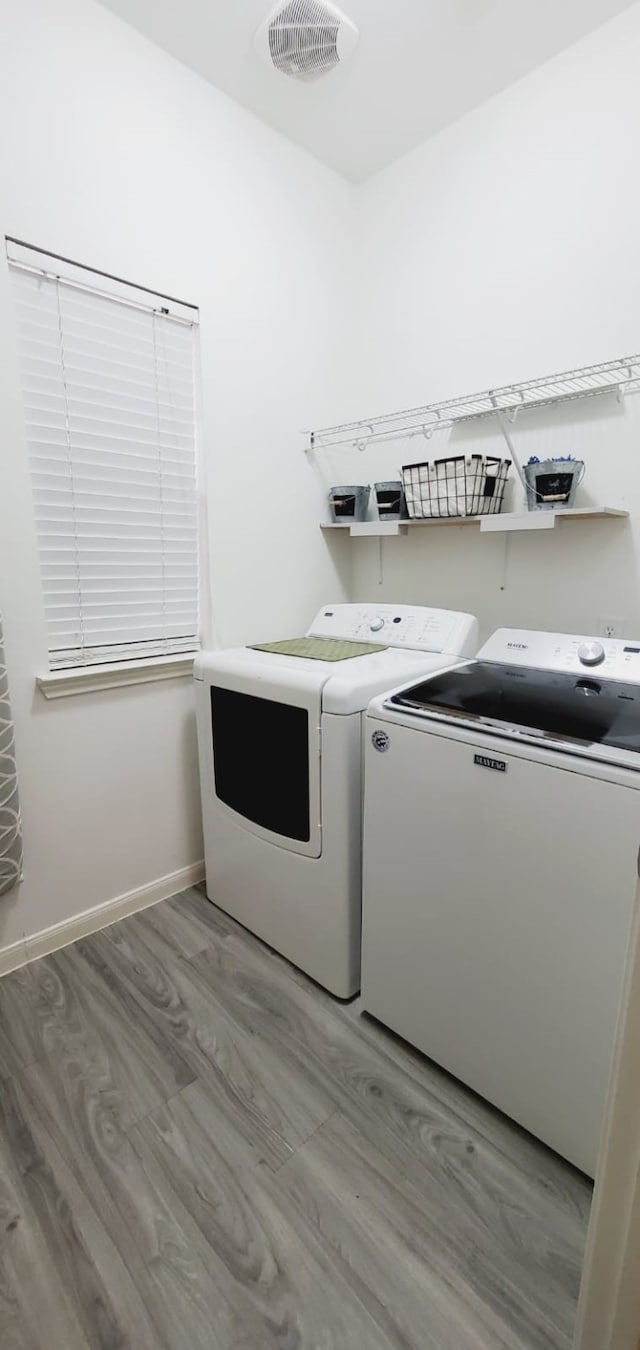 laundry area featuring light wood-style flooring, laundry area, visible vents, baseboards, and washer and dryer