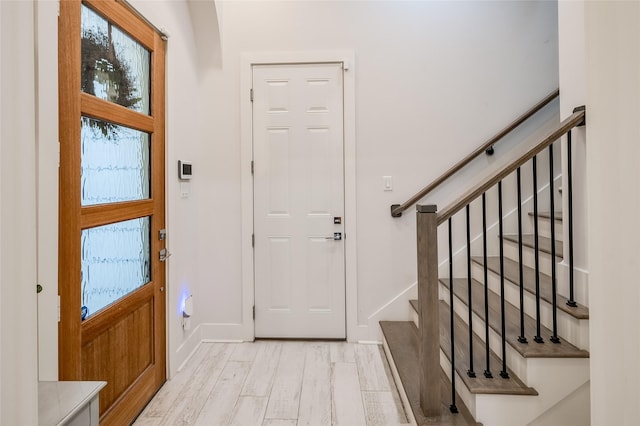 entryway featuring stairway, light wood-style flooring, and baseboards