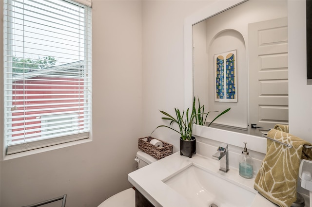 bathroom with a wealth of natural light, vanity, and toilet