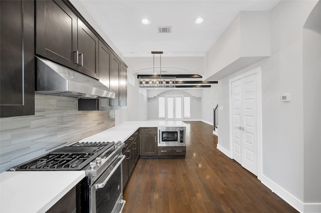 kitchen featuring stainless steel appliances, light countertops, visible vents, and under cabinet range hood