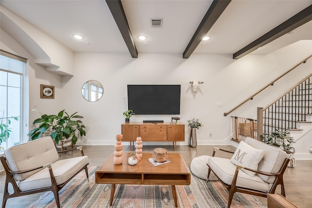 living area with baseboards, stairs, visible vents, and beamed ceiling