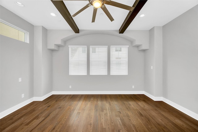 spare room featuring beamed ceiling, wood finished floors, and baseboards