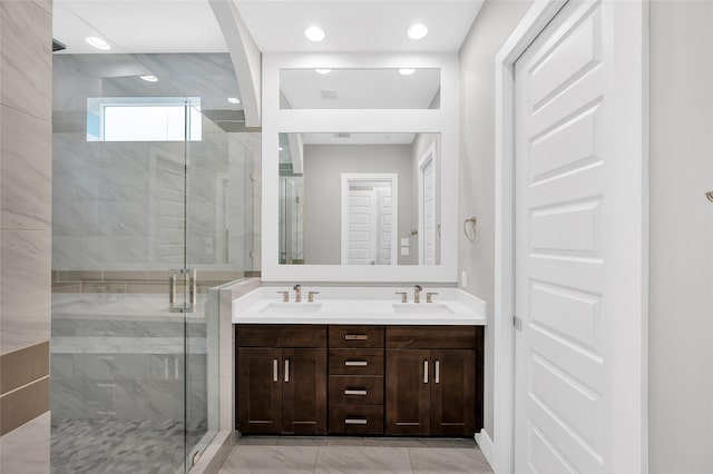 bathroom featuring a sink, marble finish floor, double vanity, and a shower stall