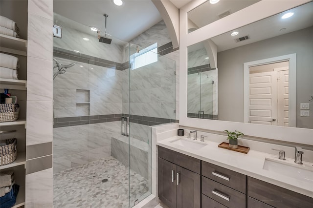 bathroom with a sink, visible vents, and a shower stall