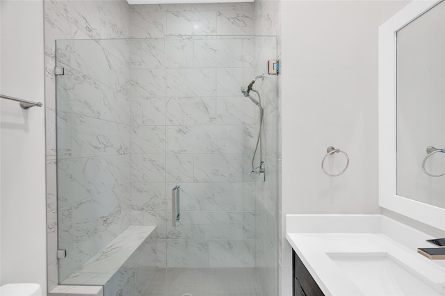 bathroom with a marble finish shower and vanity