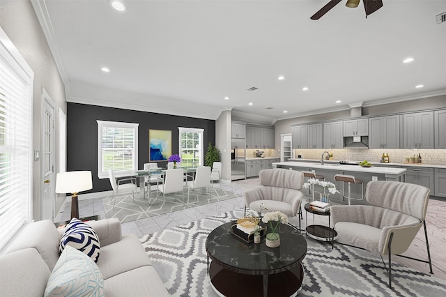 living room featuring baseboards, recessed lighting, and crown molding