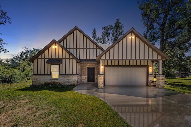 english style home with a shingled roof, board and batten siding, a front yard, a garage, and driveway