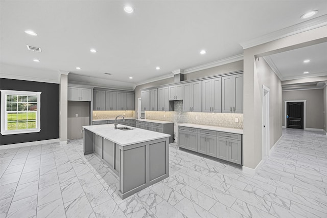 kitchen with marble finish floor, tasteful backsplash, gray cabinets, and a sink