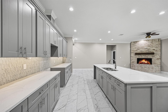 kitchen featuring recessed lighting, gray cabinets, a sink, and marble finish floor