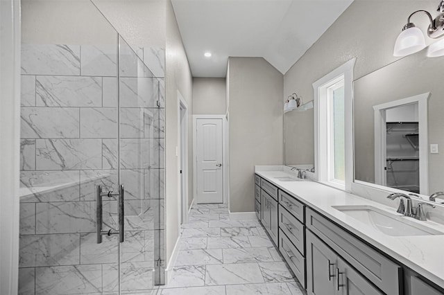 full bathroom with double vanity, marble finish floor, a sink, and a stall shower