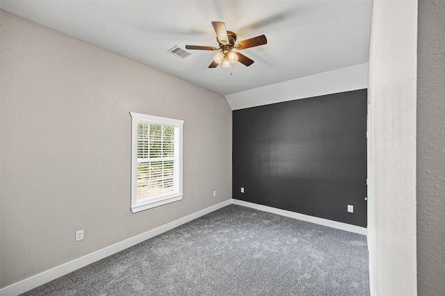 carpeted spare room featuring vaulted ceiling, ceiling fan, visible vents, and baseboards