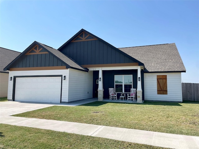 view of front of home featuring board and batten siding, a front yard, fence, and a garage