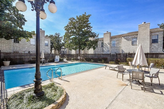 pool with fence and a patio